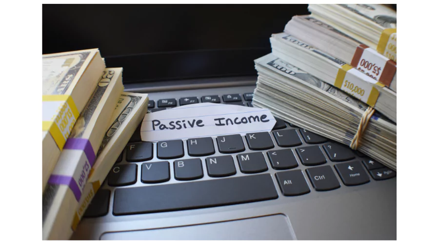 Bundles of cash on a laptop keyboard with a note reading 'Passive Income', illustrating the concept of earning money through online passive income opportunities.
