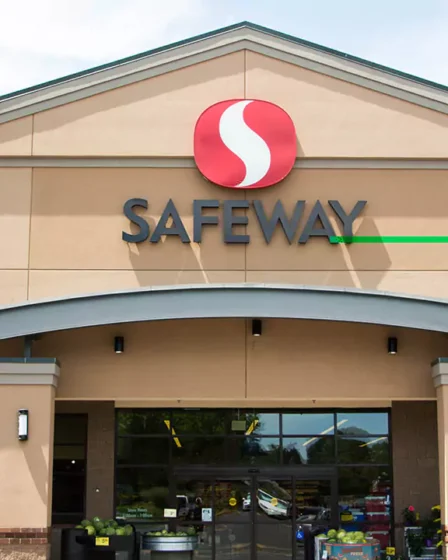 The front entrance of a Safeway grocery store with the company's logo prominently displayed above the main doors, showcasing the store's modern exterior design and hinting at the various financial services available, such as Safeway Money Order.